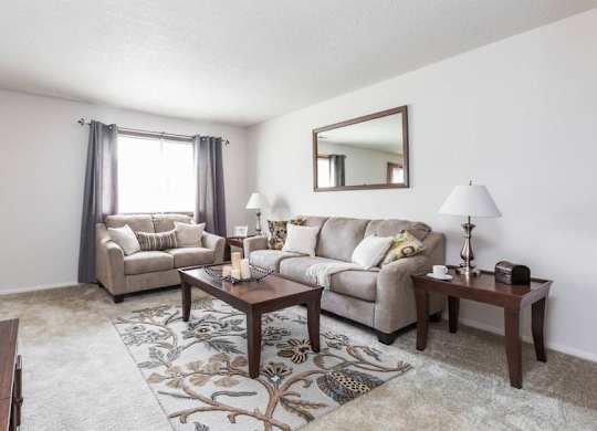 A living room with a couch, chair, and coffee table.