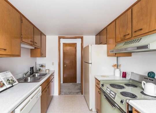 A kitchen with wooden cabinets and a white countertop.