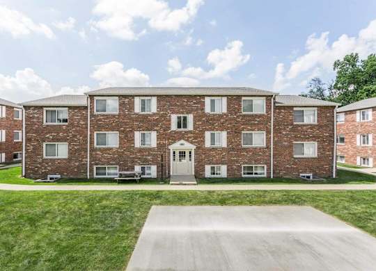 A large brick building with a driveway in front.