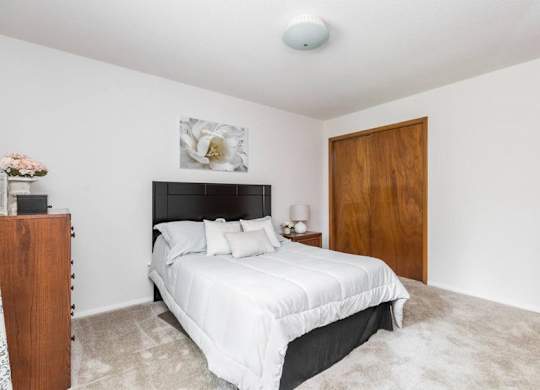 A bedroom with a large bed and a wooden door.