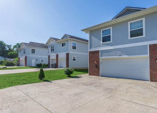 A row of houses with a driveway in front.