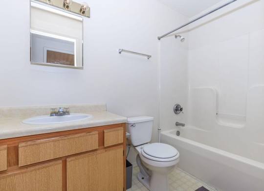 A white bathroom with a toilet, sink, and bathtub.
