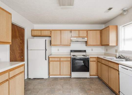A kitchen with wooden cabinets and white appliances.