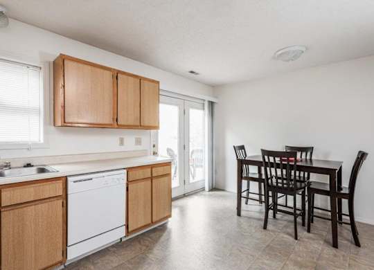 A kitchen with wooden cabinets and a dining table.