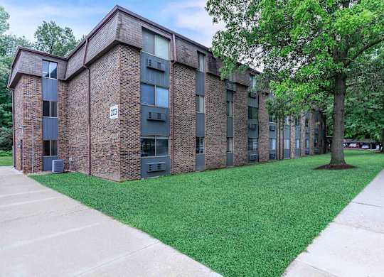 A brick building with a green lawn in front.