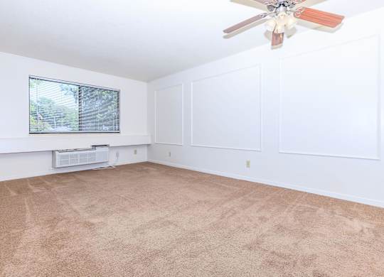 A room with a ceiling fan and a window.