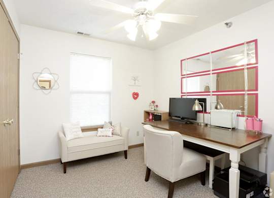 A room with a desk, chair, and a window.
