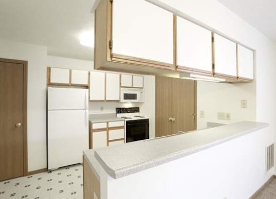 A kitchen with white appliances and a white counter top.