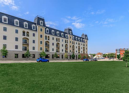 A large building with a green lawn in front of it.