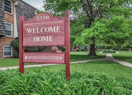 A red sign that says "Welcome Home" in front of a building.