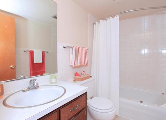 A white bathroom with a white toilet and a white tub.