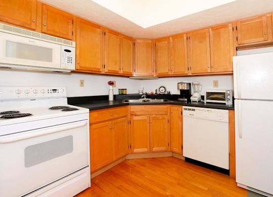A kitchen with wooden cabinets and white appliances.