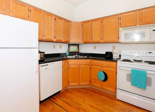 A kitchen with wooden cabinets and white appliances.