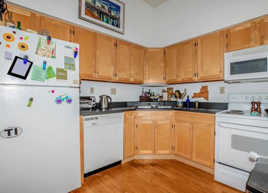 A kitchen with wooden cabinets and white appliances.