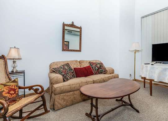 A living room with a couch, chair, and a small table.