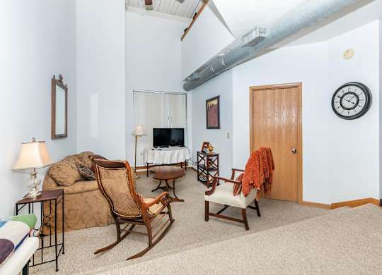 A living room with a couch, chair, and a fireplace.