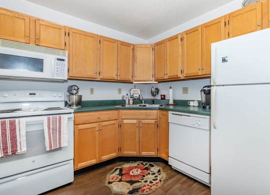 A kitchen with wooden cabinets and white appliances.