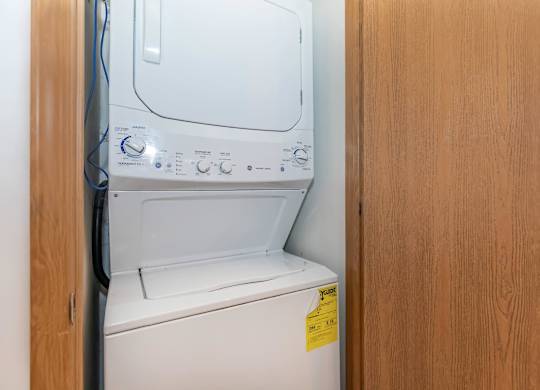 A white washing machine with a yellow sticker on the door.