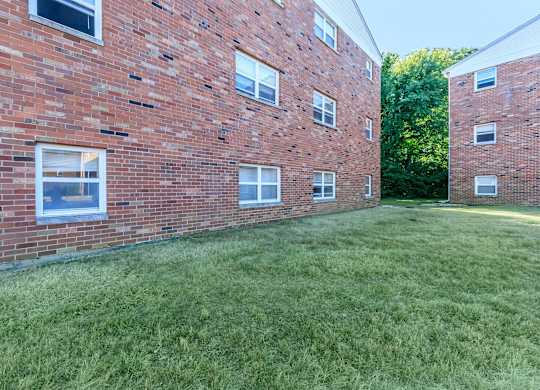 A grassy area in front of a brick building.