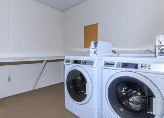Two front load washing machines in a laundry room.