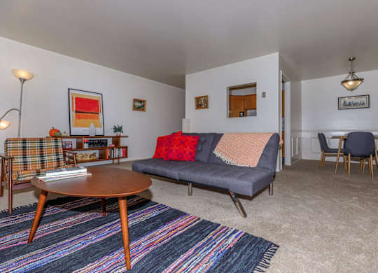 A living room with a grey couch and a wooden coffee table.