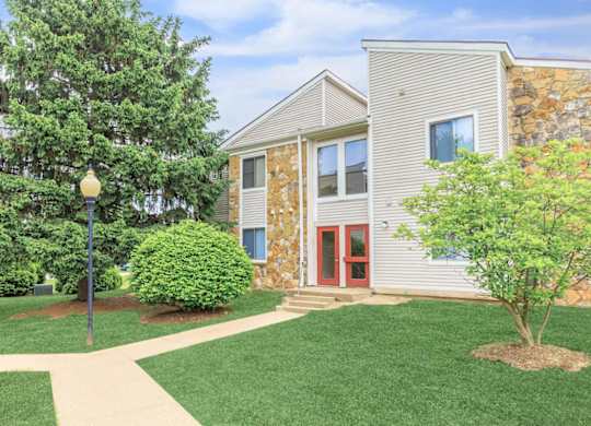A building with a red door and a tree in front of it.