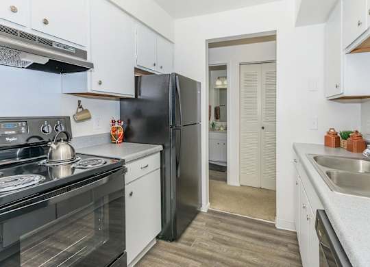 A kitchen with black appliances and white cabinets.