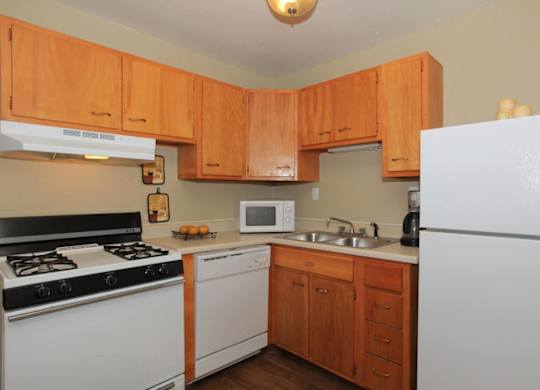 A kitchen with wooden cabinets and white appliances.
