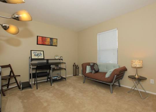 A living room with a brown couch, a chair, a dining table, and a lamp.