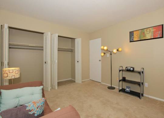 A living room with a couch, a chair, a lamp, and a picture on the wall.