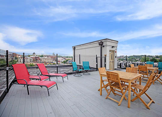 A wooden table and chairs are set up on a wooden deck.