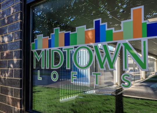 A window with a sign that says Midtown Lofts.
