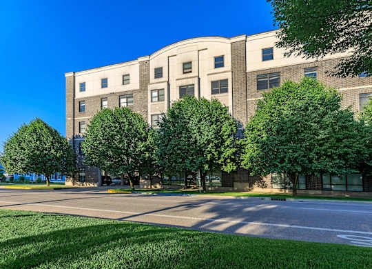 A large building with a lot of windows and trees in front.