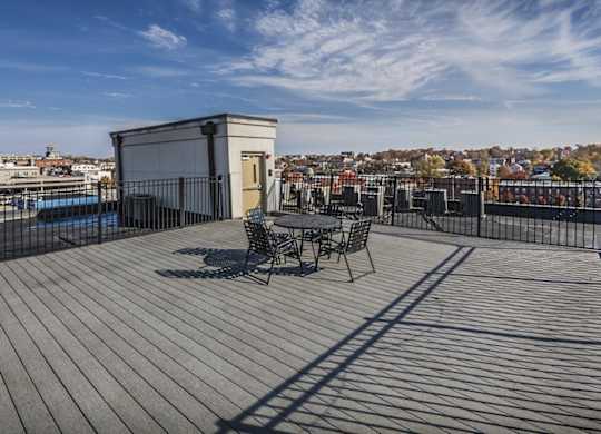 A small building with a table and chairs on a wooden deck.