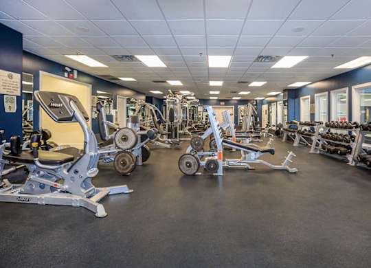 A gym with a variety of equipment including weights and machines.