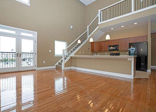 A spacious living room with a staircase leading to the upper floor.