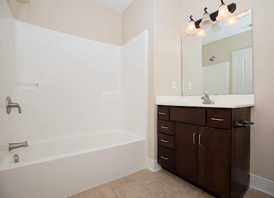 A white bathroom with a tub, sink, and toilet.