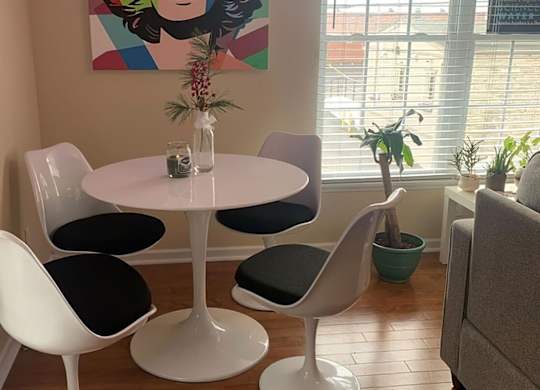 A white table with four chairs around it.