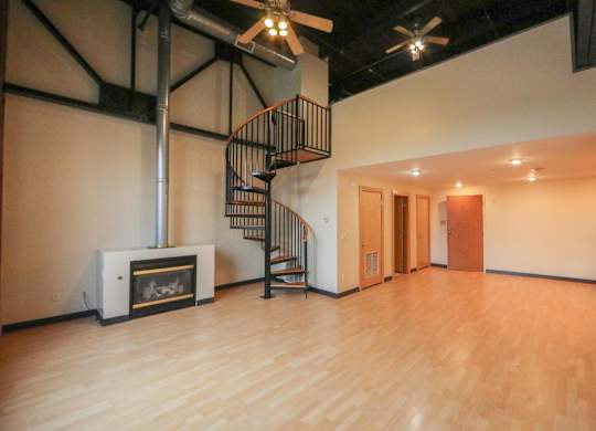 A room with a spiral staircase and a fireplace.