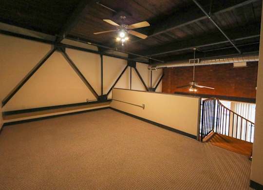 A room with a ceiling fan and a carpeted floor.