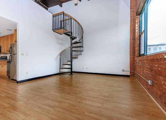 A spiral staircase in a room with wooden floors.
