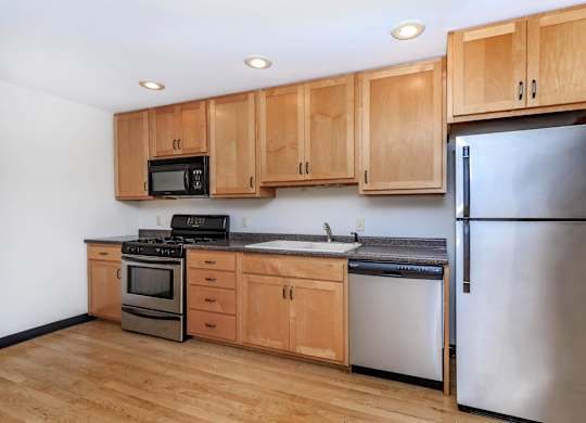 A kitchen with wooden cabinets and stainless steel appliances.