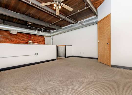 A room with a ceiling fan and a door.