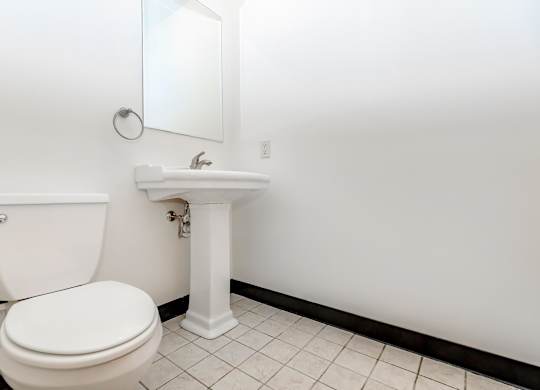A white toilet and sink in a bathroom.