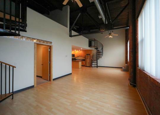 A room with wooden floors and a spiral staircase.