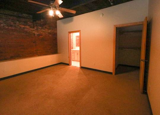 A room with a ceiling fan and a door.