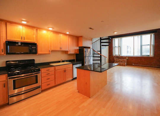 A kitchen with wooden cabinets and a black stove top oven.
