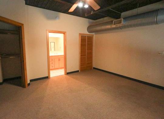 A room with a carpeted floor and a door in the middle.