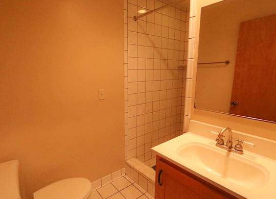 A bathroom with a toilet, sink, and shower.