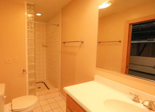 A bathroom with a toilet, sink, and shower.